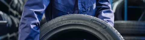 Close-up of a tyre held by a Point S tyre expert