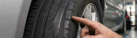Point S technician inspecting uneven tyre wear on a car tyre