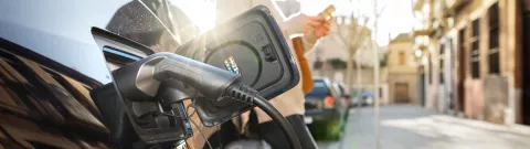 An eletric car being recharged on a street charging station