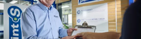 A Point S workshop manager showing MOT test results to a customer