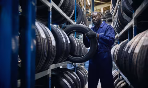 A Point S technician choosing the right tyres from a tyre rack and checking its size