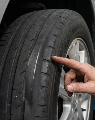 Point S technician inspecting uneven tyre wear on a car tyre