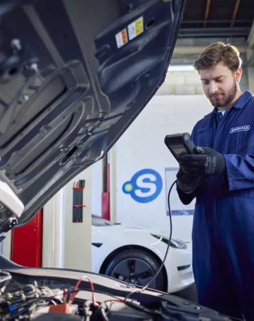A Point S technician performing a car battery check