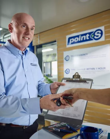 A Point S workshop manager showing MOT test results to a customer